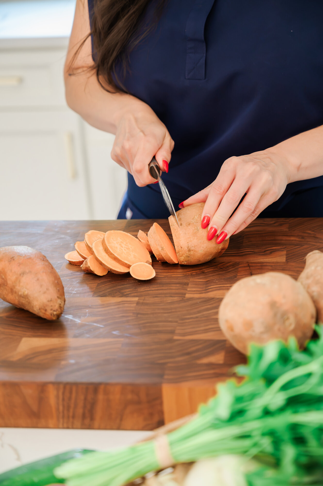 Chopping fresh sweet potatoes on a wooden board