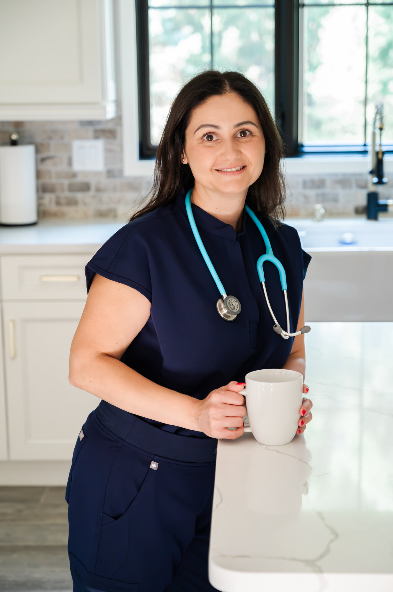 Loreta in navy scrubs with her stethoscope